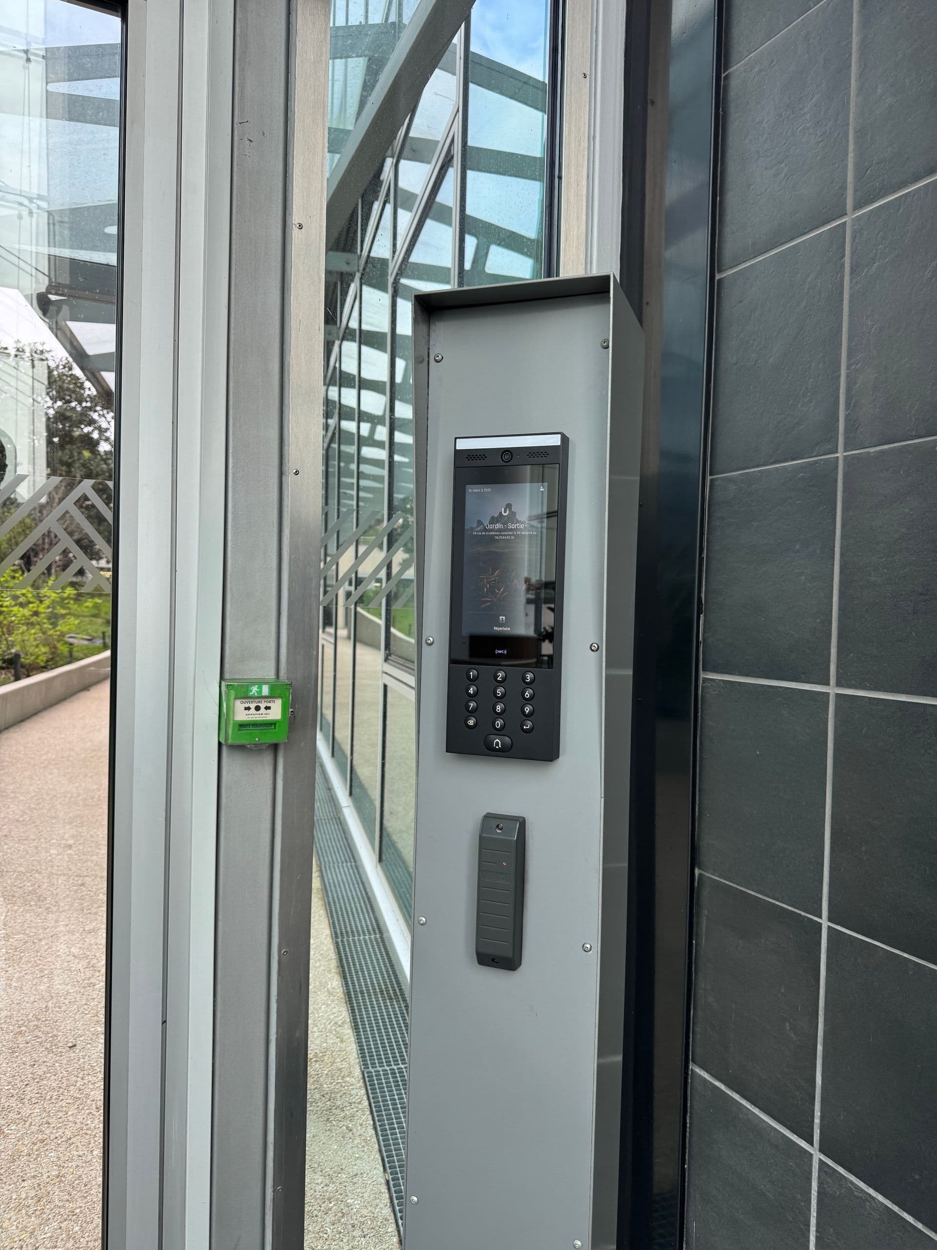 Platine d'interphone et lecteur de badge à une entrée du bâtiment